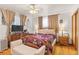 Relaxing main bedroom features a ceiling fan, dark wood floors, and a large window at 1275 Otis St, Lakewood, CO 80214