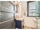 Charming bathroom featuring a modern vanity, round mirror, and a glass-enclosed shower at 1749 S Lincoln St, Denver, CO 80210
