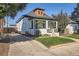 View of home with a well-manicured lawn and a driveway leading to a detached garage at 1749 S Lincoln St, Denver, CO 80210