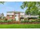 Expansive backyard featuring a large deck, lush lawn, and vibrant garden beds on a terraced retaining wall at 7330 Routt St, Arvada, CO 80005