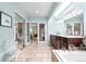 Bright bathroom featuring skylight, tile floor, and double doors to bedroom at 7330 Routt St, Arvada, CO 80005