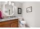 Half bath featuring granite counters and decorative fixtures at 7330 Routt St, Arvada, CO 80005
