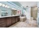 Bright bathroom featuring skylight, double vanity, soaking tub and stone tile at 7330 Routt St, Arvada, CO 80005