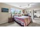 Comfortable bedroom with side tables, a large window bringing the outdoors in, and mirrored closet doors at 7330 Routt St, Arvada, CO 80005