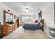 Bright bedroom featuring large window, fan, and ample storage in a wooden dresser at 7330 Routt St, Arvada, CO 80005