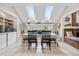 Sunlit dining area with skylights and a view of the fireplace and greenery at 7330 Routt St, Arvada, CO 80005