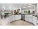 The kitchen includes a tile backsplash, stainless steel appliances and a view of the fireplace and dining room at 7330 Routt St, Arvada, CO 80005