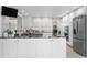 Modern kitchen featuring white cabinetry, granite countertops, and stainless steel appliances at 7330 Routt St, Arvada, CO 80005