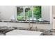 Close-up of kitchen sink featuring modern fixtures, granite countertop, and backsplash at 7330 Routt St, Arvada, CO 80005