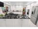 Modern kitchen featuring stainless steel appliances, white cabinets, and a black marble countertop island at 7330 Routt St, Arvada, CO 80005