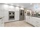 Updated kitchen featuring stainless steel appliances, white cabinets and a breakfast bar at 7330 Routt St, Arvada, CO 80005