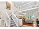 Open-concept living room with a staircase, hardwood floors, and large windows for natural light at 7330 Routt St, Arvada, CO 80005