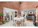 Bright sunroom with brick walls, a dining table, and views of the backyard at 7330 Routt St, Arvada, CO 80005