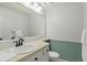 Bright bathroom featuring a framed mirror, white cabinets, and traditional fixtures and wainscoting at 1907 S Helena St # G, Aurora, CO 80013