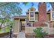 Charming townhome with brick chimney, white picket fence, and a landscaped front yard at 1907 S Helena St # G, Aurora, CO 80013