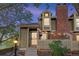 Charming two-story home boasts a brick chimney and cozy string lights enhancing the entryway's appeal at 1907 S Helena St # G, Aurora, CO 80013