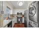 Compact kitchen featuring stainless steel appliances and a stacked washer/dryer at 1907 S Helena St # G, Aurora, CO 80013