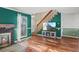 Open-concept living room with hardwood floors, a fireplace, staircase, and an entertainment setup for modern living at 1907 S Helena St # G, Aurora, CO 80013