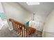 Carpeted staircase with wooden railing leading to the home's main level with skylight and front door at 1907 S Helena St # G, Aurora, CO 80013