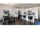 Open-concept kitchen and dining area featuring an island with bar seating and stainless steel appliances at 11823 Barrentine Loop, Parker, CO 80138