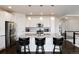 Spacious kitchen featuring an island with bar stools, stainless steel appliances, and white cabinetry at 11823 Barrentine Loop, Parker, CO 80138