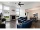 Relax in this living room boasting tall windows, a fireplace, and comfortable blue leather seating at 11823 Barrentine Loop, Parker, CO 80138