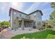 Back exterior of a house featuring a patio, manicured lawn, and landscaped yard at 525 Grenville Cir, Erie, CO 80516