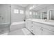 Modern bathroom with a double sink vanity, a tub with shower, and great lighting at 525 Grenville Cir, Erie, CO 80516