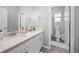 Well-lit bathroom with a double sink, a large mirror, and an adjacent toilet room at 525 Grenville Cir, Erie, CO 80516
