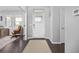 Bright foyer featuring hardwood floors, a white front door, and an adjacent office space at 525 Grenville Cir, Erie, CO 80516