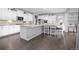 Bright kitchen features white cabinets, large island with bar seating, stainless appliances, and hardwood floors at 525 Grenville Cir, Erie, CO 80516