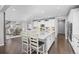 Bright kitchen features white cabinets, large island with bar seating, stainless appliances, and hardwood floors at 525 Grenville Cir, Erie, CO 80516