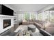 Spacious living room features a fireplace, built-in shelves, large windows, hardwood floors and a plush sectional at 525 Grenville Cir, Erie, CO 80516