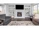 Cozy living room features a fireplace, built-in shelves, hardwood floors, and comfortable seating at 525 Grenville Cir, Erie, CO 80516