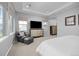Relaxing main bedroom featuring large windows, a sitting area and an entertainment center at 525 Grenville Cir, Erie, CO 80516