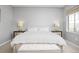 Bright main bedroom offering a king bed, side tables with lamps, and a storage bench at 525 Grenville Cir, Erie, CO 80516