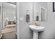 Modern powder room featuring a pedestal sink, decorative mirror, and neutral paint at 525 Grenville Cir, Erie, CO 80516
