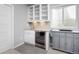Convenient basement wet bar featuring sleek cabinetry, a sink, and a beverage cooler at 525 Grenville Cir, Erie, CO 80516