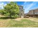Backyard view of lawn, large trees, house and fence at 8935 Sleepy Grass Ct, Parker, CO 80134