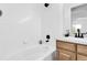 White tiled bathroom with black hardware, sink and vanity with warm wood finish at 8935 Sleepy Grass Ct, Parker, CO 80134