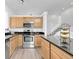 Well-lit kitchen with stainless steel appliances, wooden cabinetry, and an island next to the staircase at 8935 Sleepy Grass Ct, Parker, CO 80134