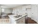 Modern kitchen features a central island with a stainless steel sink and white cabinets at 5718 Ranch St, Mead, CO 80504