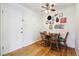 Dining area with wood floors and seating for four next to a white door at 85 N Grant St # 28, Denver, CO 80203
