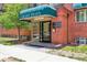 Building entrance with a green awning, glass door, and brick facade at 85 N Grant St # 28, Denver, CO 80203