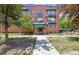 Exterior shot of the Grant Plaza apartment building, showcasing its red brick facade and well-maintained landscaping at 85 N Grant St # 28, Denver, CO 80203