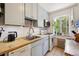 Bright kitchen featuring light blue cabinets, butcher block counters, subway tile backsplash, and stainless steel appliances at 85 N Grant St # 28, Denver, CO 80203