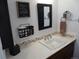 Bathroom vanity featuring decorative tile trim, mirror, and towel rack at 9705 Canon Dr, Sedalia, CO 80135