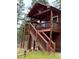 Charming cabin exterior featuring a rustic stairway leading to a spacious wooden deck at 9705 Canon Dr, Sedalia, CO 80135