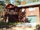 Inviting cabin-style home with wooden siding, deck, and garage in a serene, wooded setting at 9705 Canon Dr, Sedalia, CO 80135