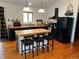 Spacious kitchen features wood flooring, island with seating, and black appliances at 9705 Canon Dr, Sedalia, CO 80135
